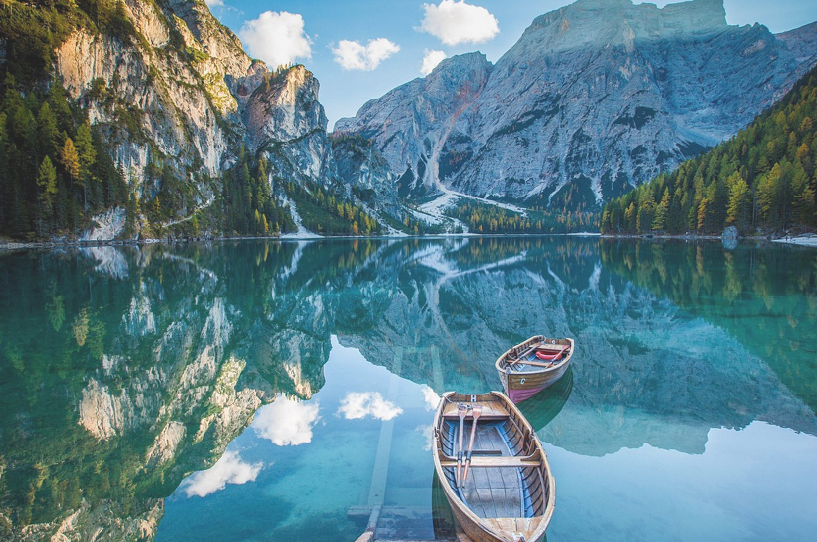 Un lac de montagne avec bateaux en bois, harmonie entre l’homme et la nature